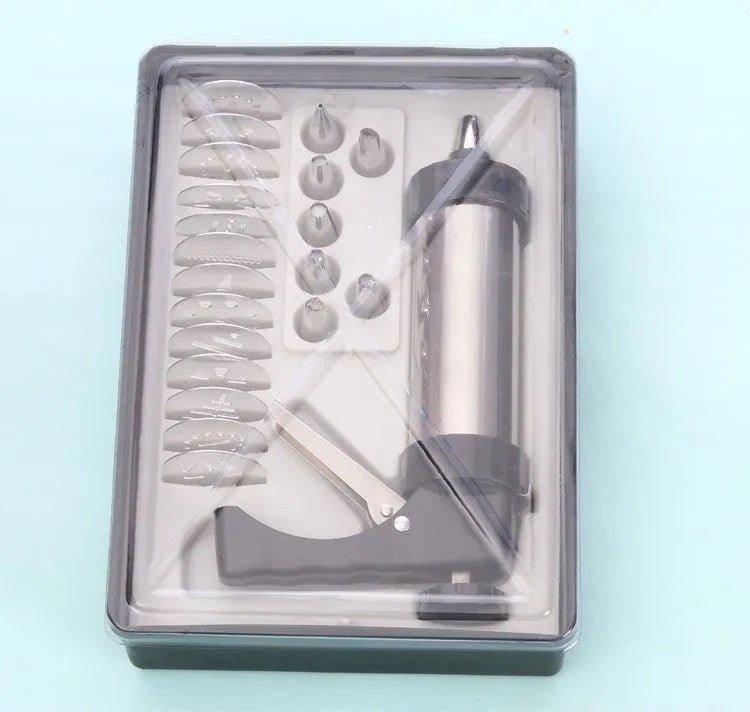 Stainless steel biscuit press machine with assortment of cookie moulds and piping nozzles on a kitchen worktop