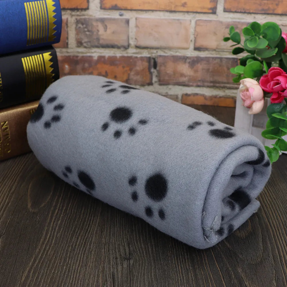 Pet warm blanket with paw print design double-sided fleece in blue colour, laid flat on a surface