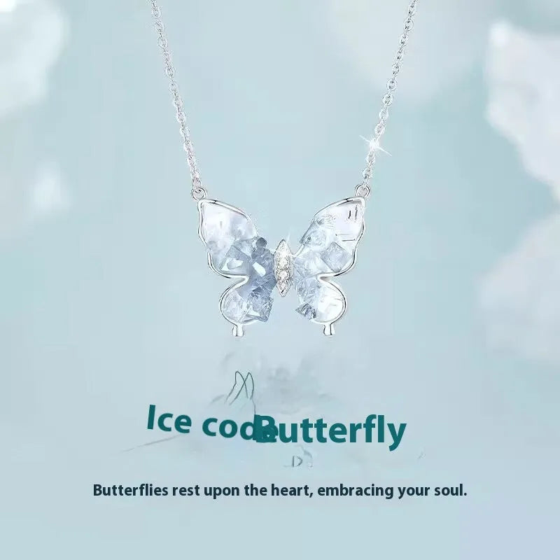 Close-up of a silver necklace with a detailed ice rain butterfly pendant on an O-ring chain.
