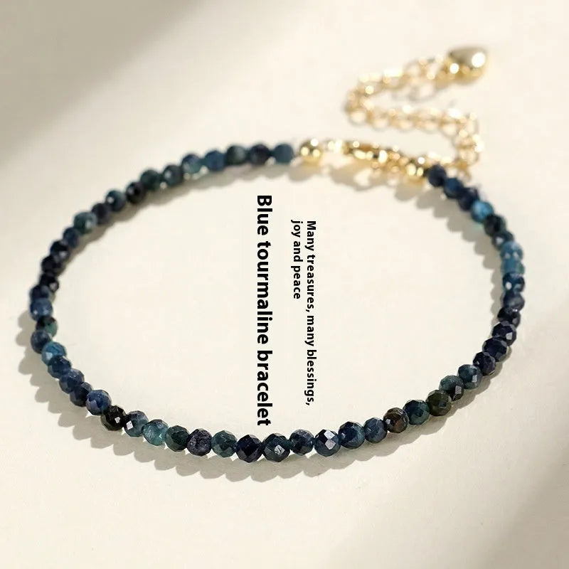 Close-up of a women's bracelet with 3mm blue tourmaline cut beads and silver-toned spacer beads on a wrist.