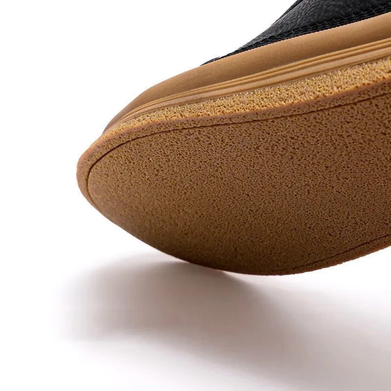 Men's black and white casual leather shoes with round toe and flat rubber sole.