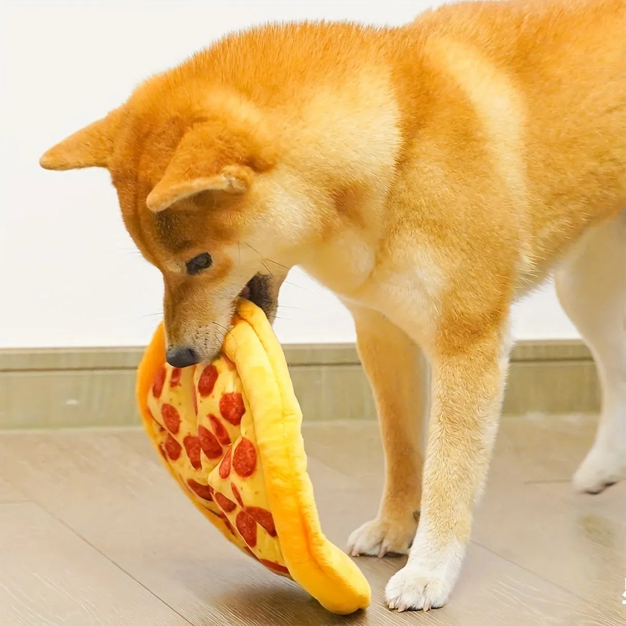 Yellow rubber pizza-shaped dog chew toy with squeaker for interactive play.