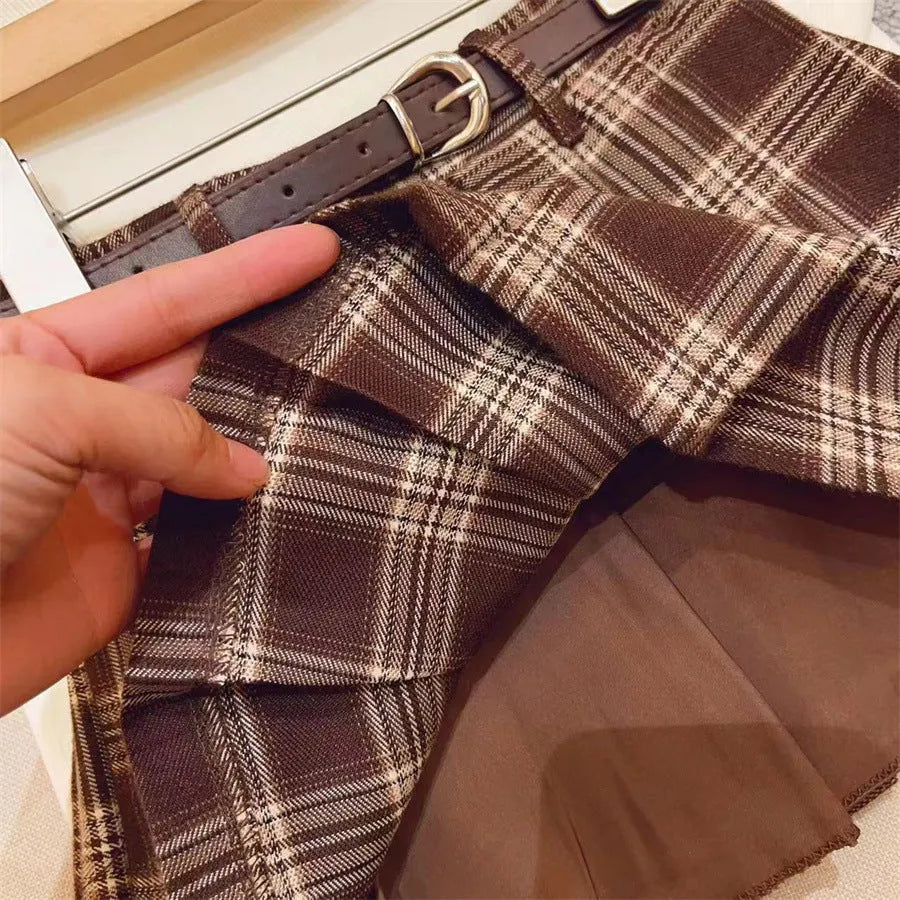 Girls cotton plaid pleated A-line skirt on a hanger, showing its length and pattern.