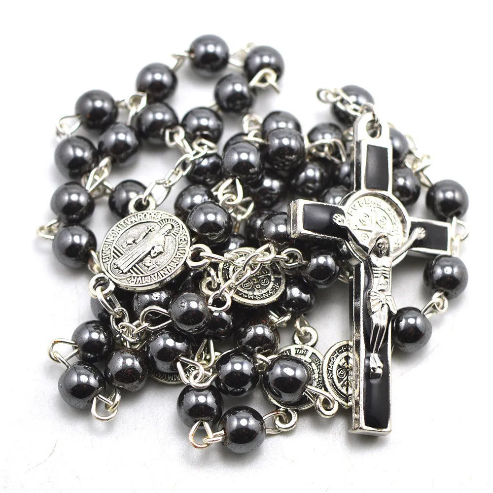 Black hematite rosary necklace with zinc alloy cross and triangle on dark background