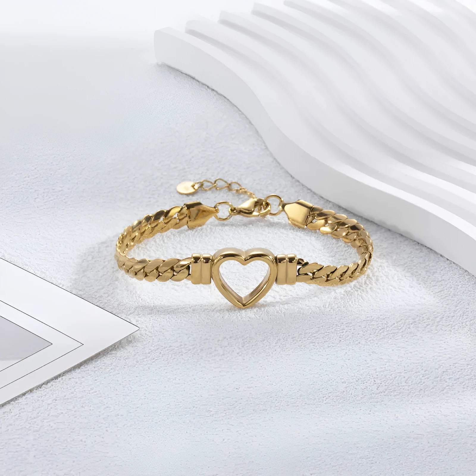 Fashion simple hollow heart titanium steel bracelet in BR-26 gold finish on a neutral background