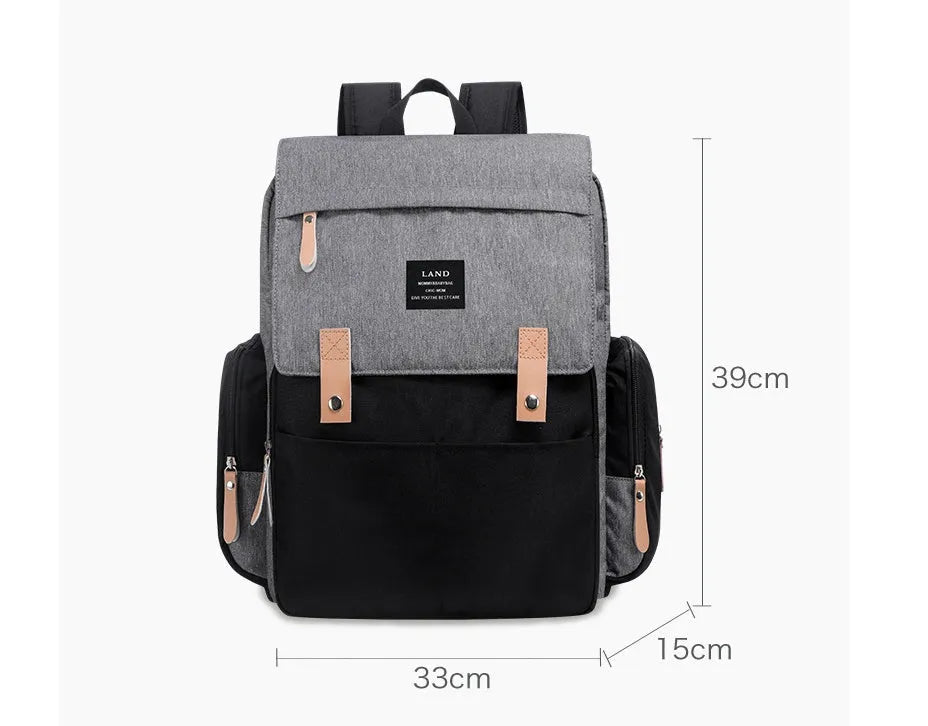 LAND Mommy large grey Oxford cloth diaper backpack with changing mat, shown on a table