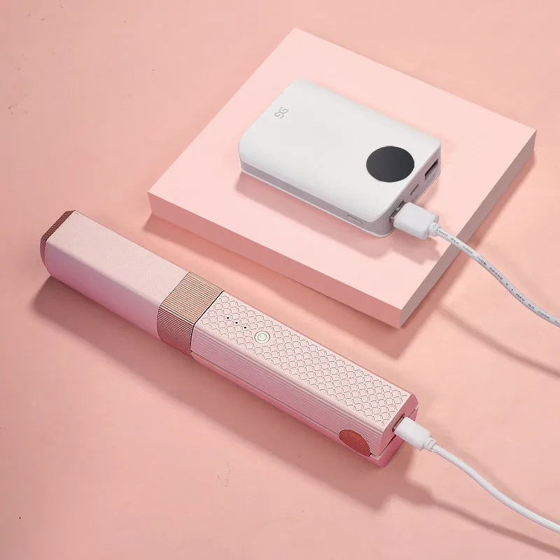 Pink and green cordless USB hair straightener and curler with ceramic plates, shown with USB cable.