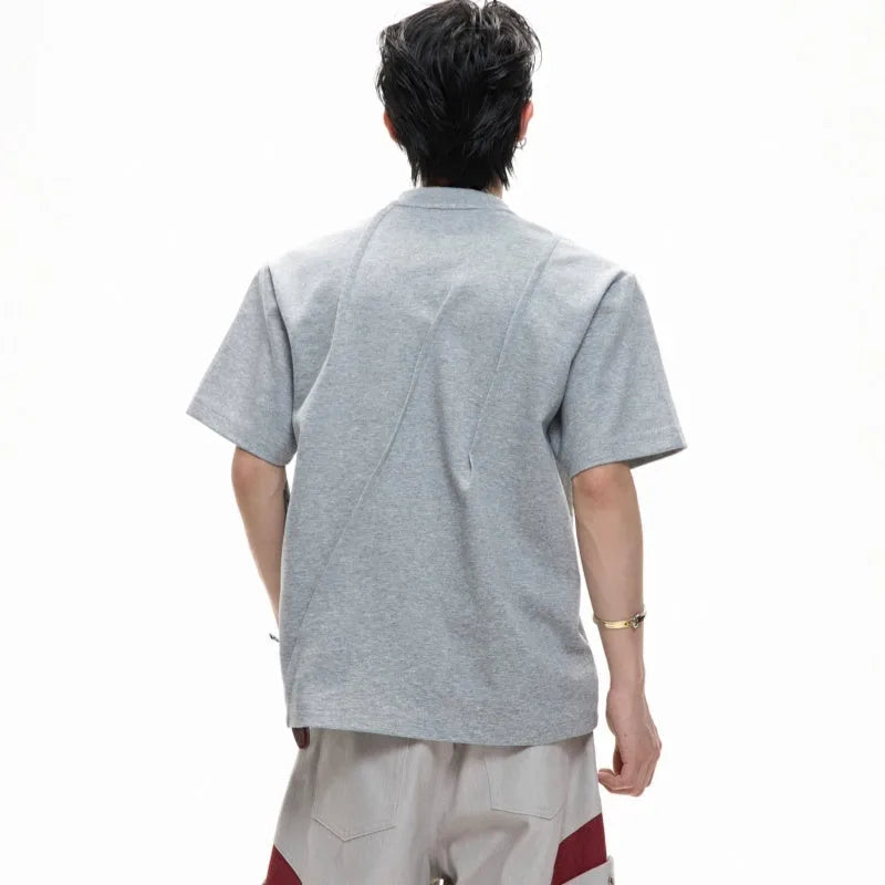 Men's loose black cotton T-shirt with textured pleats and asymmetric design detail.