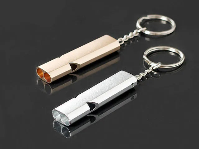 Silver and gold coloured aluminium alloy double-hole outdoor survival whistle with keychain.