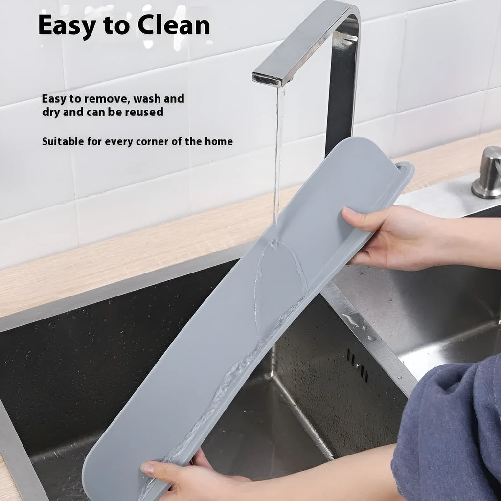 Grey blue silicone sink water blocking plate measuring 52mm by 85mm on a kitchen counter.
