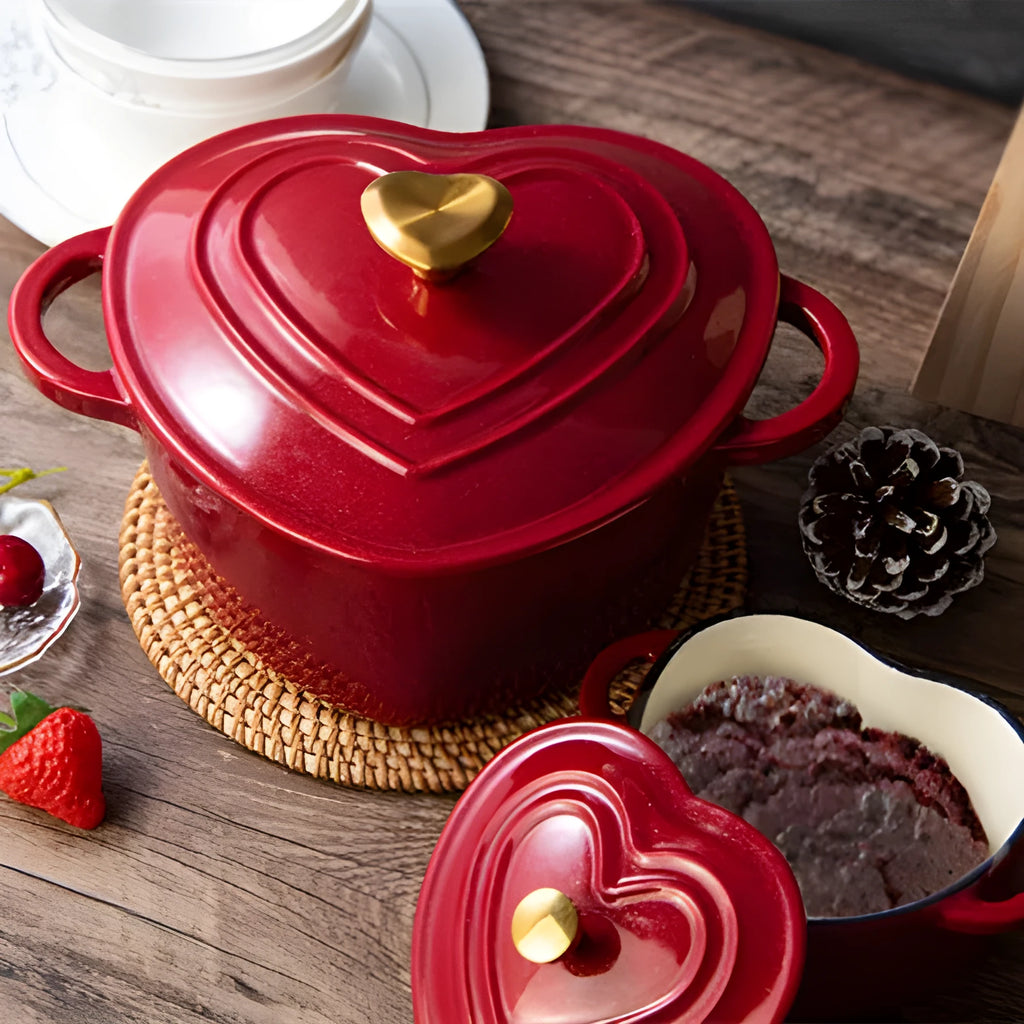 Heart-shaped cast iron enamel stew pot in Milk White with lid on a stovetop