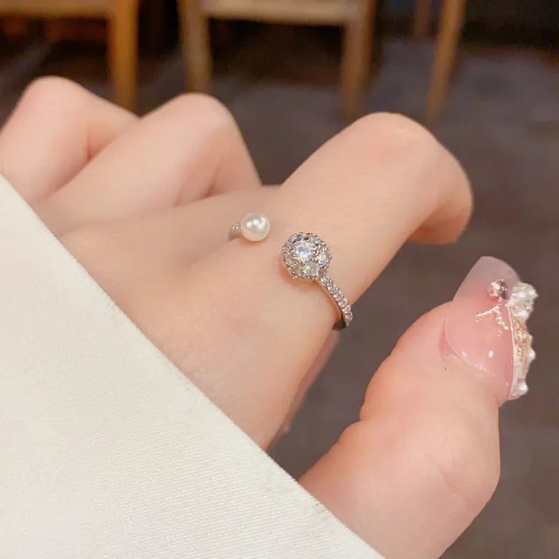 Gold and silver coloured open-end ring with round zircon on a geometric band.