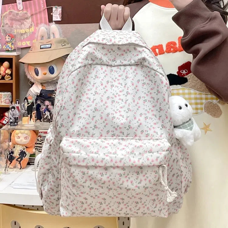 Japanese-style floral print girls' backpack in Oxford cloth with curved shoulder straps, shown in pink floral or white tulip scarf bear.