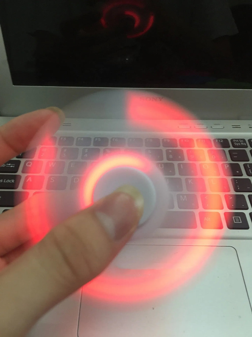Square white Bluetooth speaker and fidget spinner toy with control buttons, measuring 80mm.