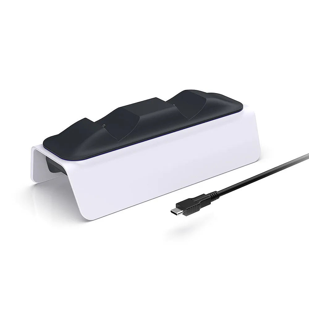 White PS5 dual controller charger with LED indicators and two gamepads docked on a wooden desk