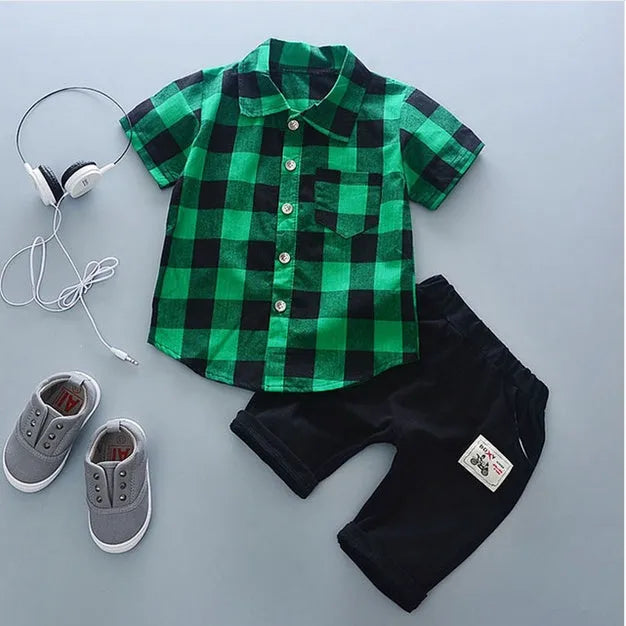 Baby boy wearing a blue crocodile print cotton t-shirt and matching blue shorts summer outfit set.