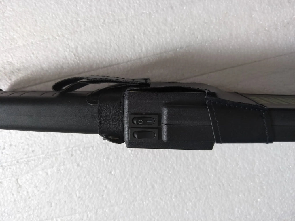 Black handheld metal detector with leather carrying case, 410mm length, for security screening