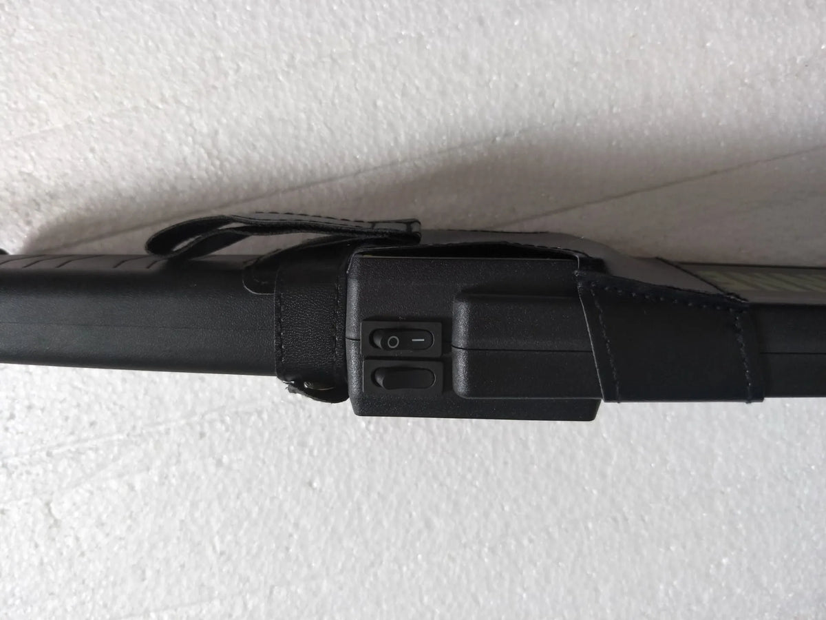 Black handheld metal detector with leather carrying case, 410mm length, for security screening