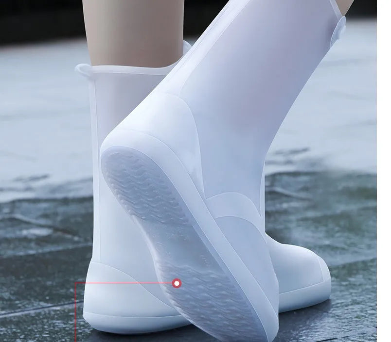 White high-top PVC reusable shoe covers for women on a rainy day background.