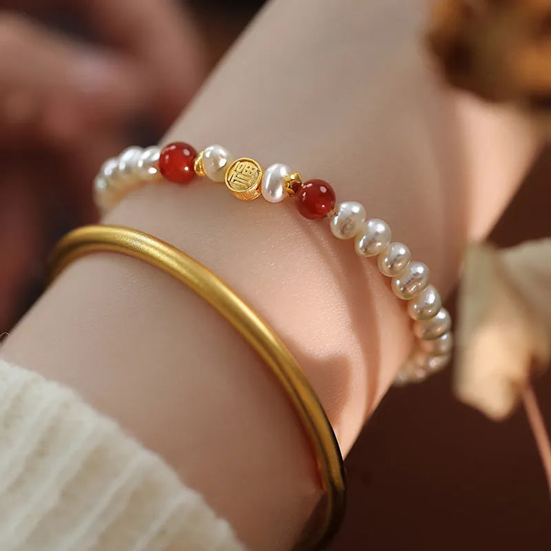 Natural freshwater pearl bracelet with Fu character charm on white background, silver chain, women's accessory