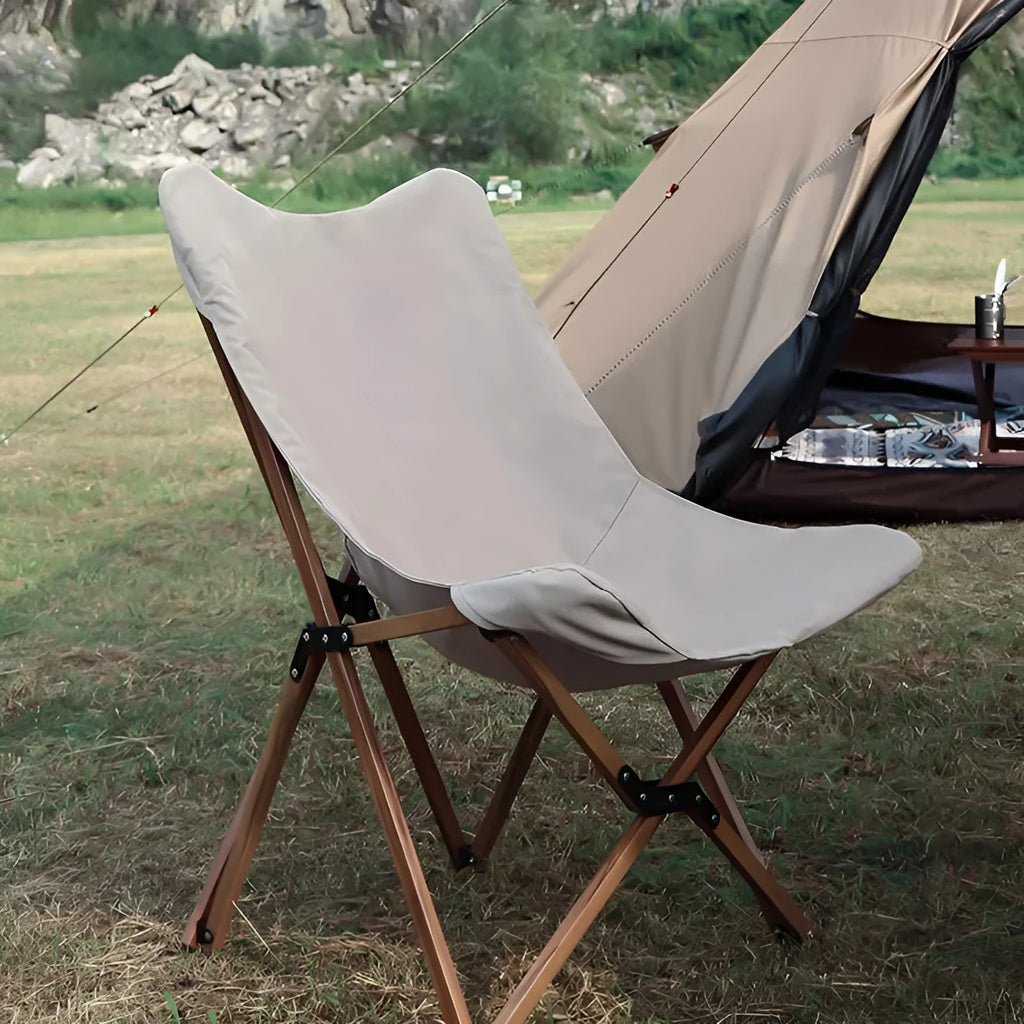 Folding camping chair with aluminium frame, wood grain finish, handrails, and rotating seat in outdoor setting