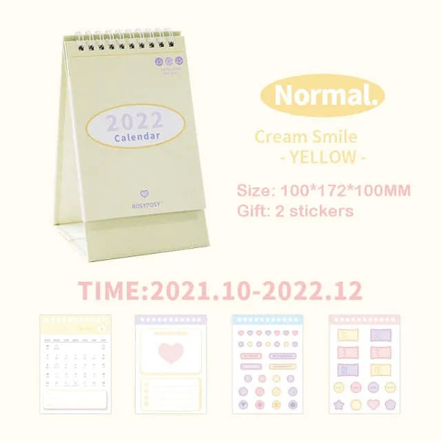 Cream coil-bound desk calendar for 2022, paper, Regular size, on a desk with month view visible