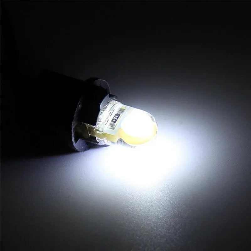 Ten T10 LED bulbs for cars in various colours including blue, red, and white, showing their 21.5mm length.