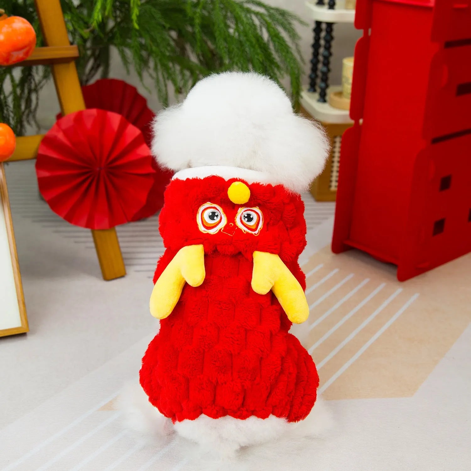 Red fluffy pet jacket with cartoon dragon design on a dog, showing velvet texture and fit.