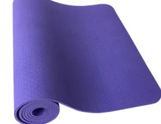 6mm TPE beginner yoga mat in black, rolled on wooden floor with textured non-slip surface visible