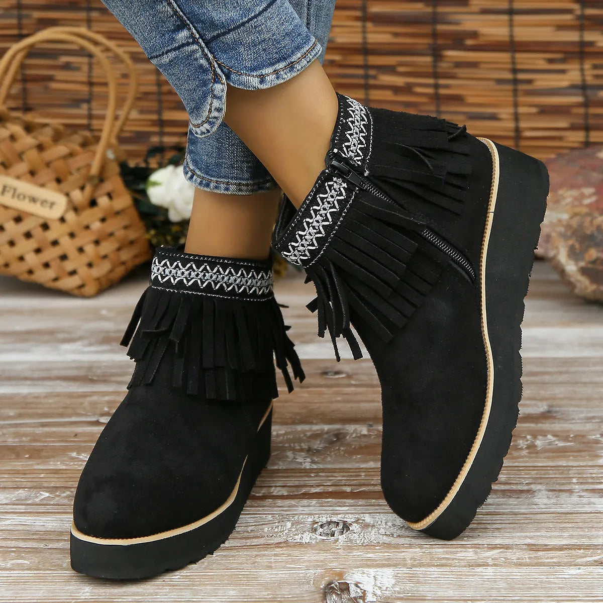 Women's black suede wedge ankle boots with side zipper, tassel detail, and thick rubber sole.