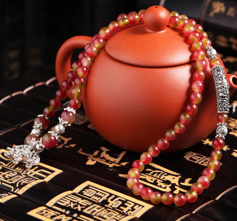 Natural watermelon crystal bracelet with Chinese knot design showing elephant style beads