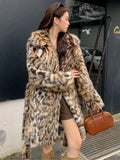 A women's long faux fur coat with a fur collar and pockets, shown in a street fashion style.