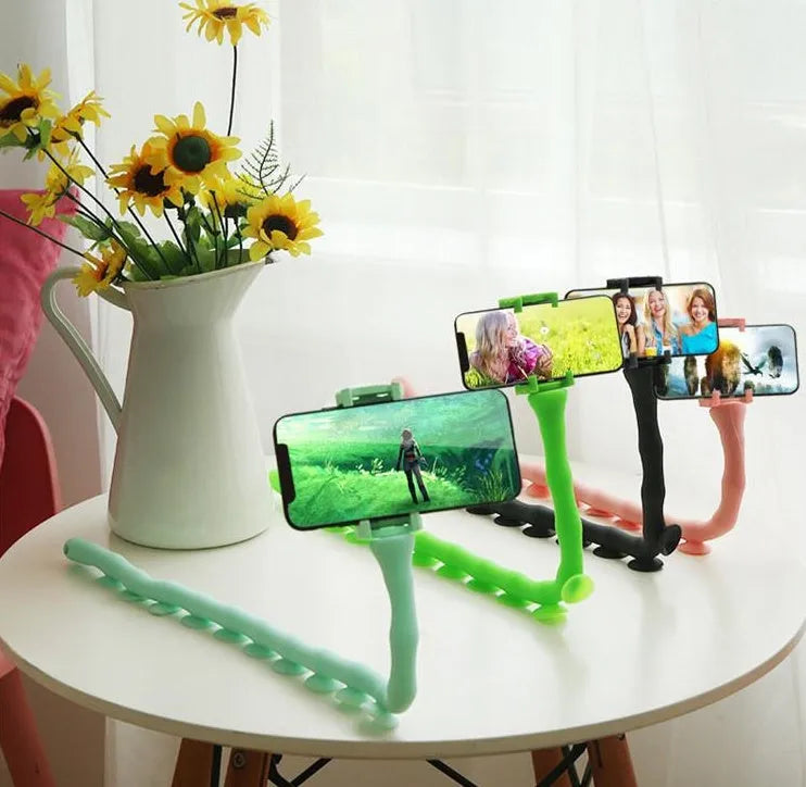 Flexible worm-style lazy bracket mobile phone holder with long silicone arm and black rubber suction cup base.