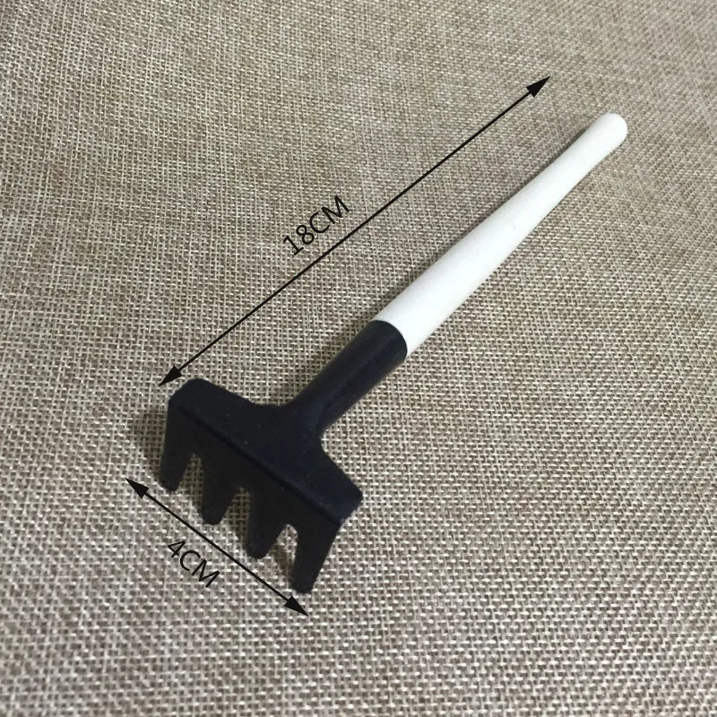 Succulent gardening tool set showing a small watering can, bucket, mini shovel, rake, tweezers, and scissors on a table.