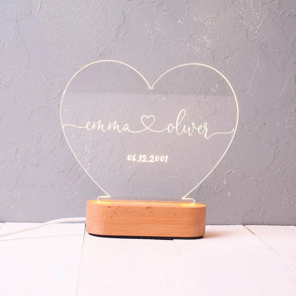 Custom acrylic night light with engraved names and date, lit by LED base.