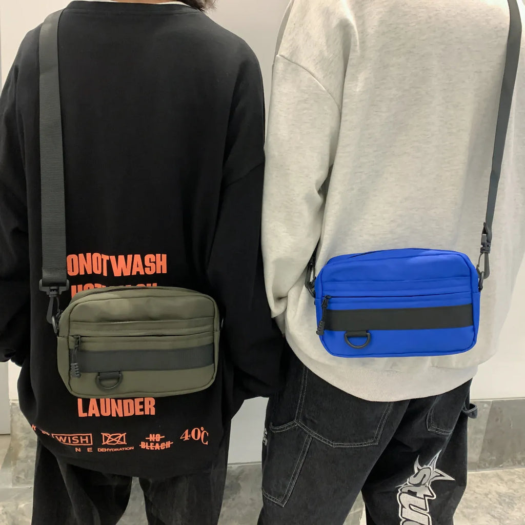 Men's street-style nylon messenger crossbody bag in black, shown with sewing thread detail.