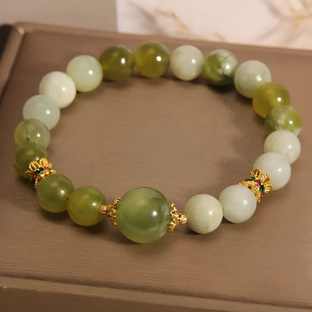Xiuyan jade green women's bracelet with sweet Mori style design on a wrist.