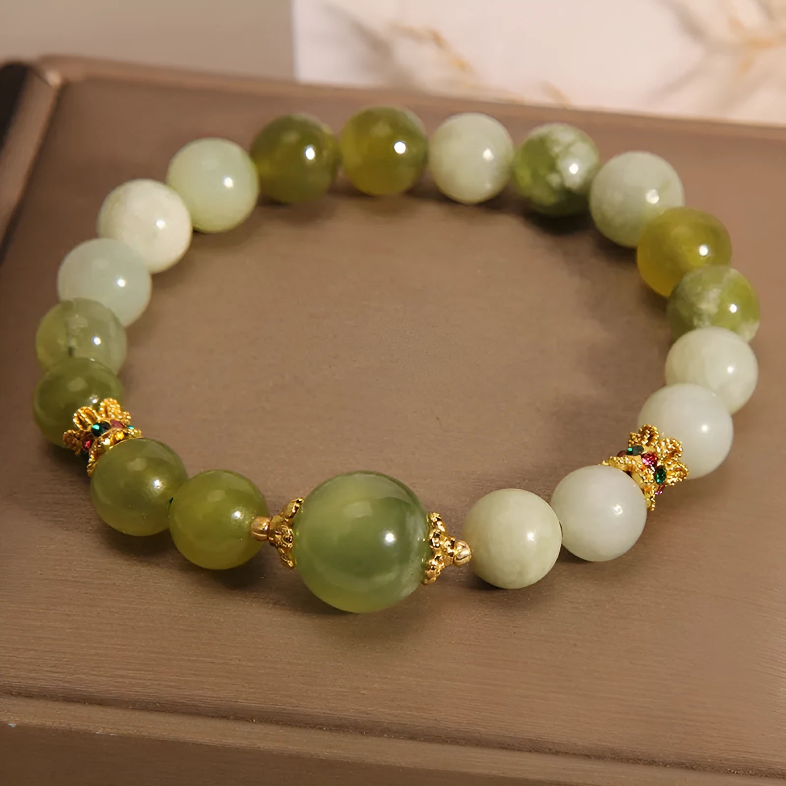 Xiuyan jade green women's bracelet with sweet Mori style design on a wrist.