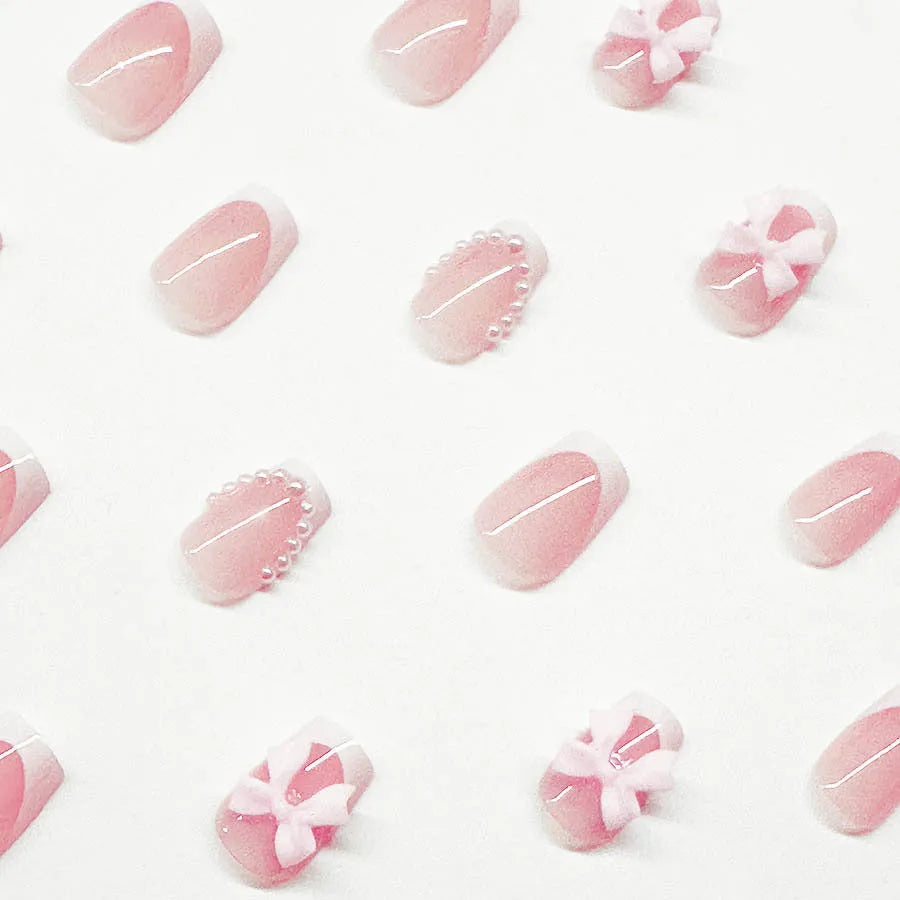 Short white French style press-on nails with bow, tulip, and leopard print designs.