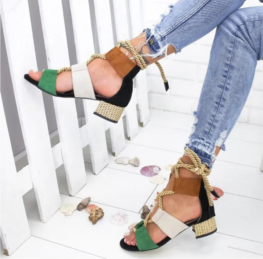 Women's beige suede sandals with a thick middle heel, front strap, and ankle strap, showing a round fish mouth toe.