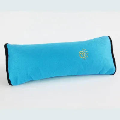Children car pillow in grey micro-suede fabric attached to a car seat belt shoulder strap