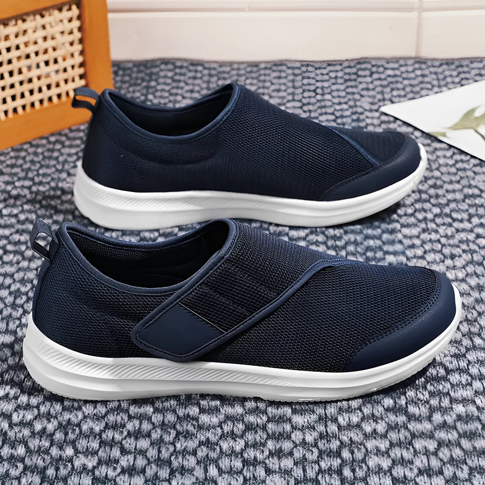 A pair of grey mesh walking shoes with a Velcro strap closure, shown on a white background.