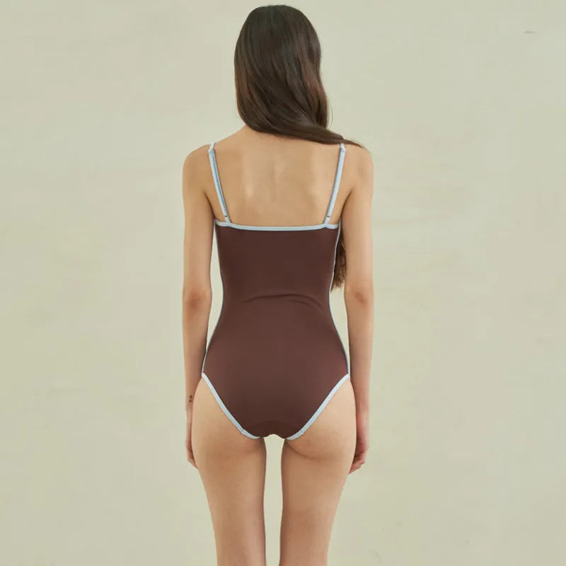 Brown women's triangle top one-piece swimsuit on hanger showing front design