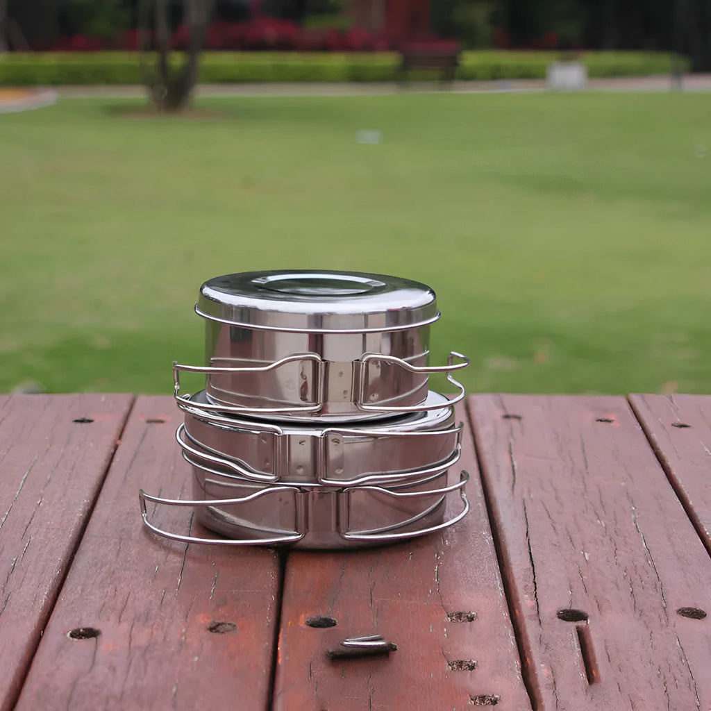 Stainless steel outdoor camping cookware set showing four round silver pots designed for 2-3 people