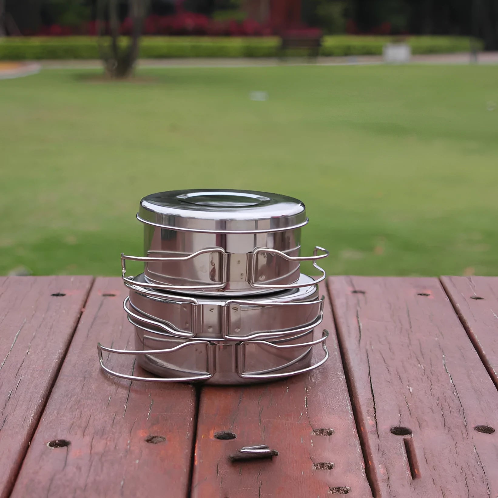 Stainless steel outdoor camping cookware set showing four round silver pots designed for 2-3 people