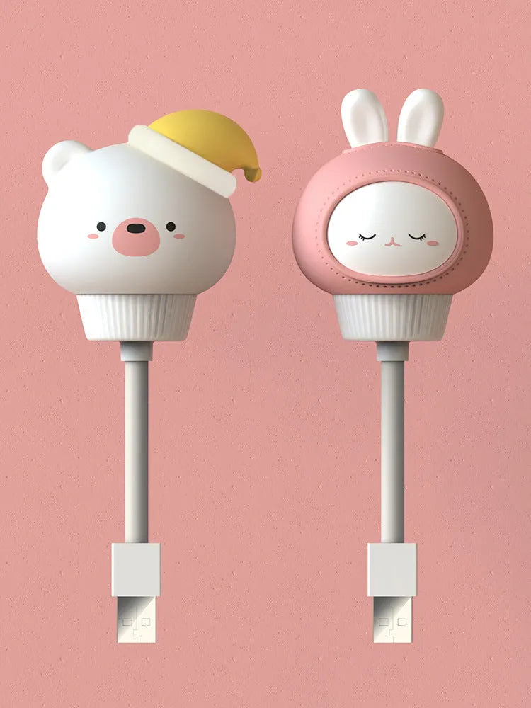 Cute cartoon animal USB night light in bear shape with soft white glow on a bedside table.
