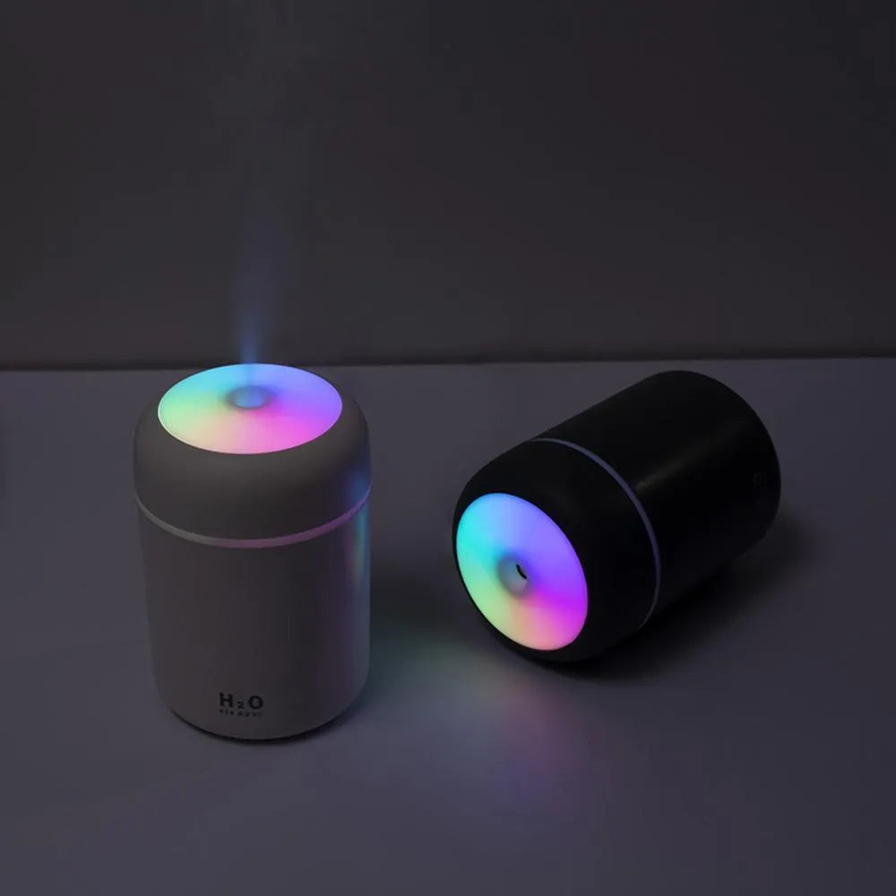 Pink, white, or navy blue USB mini humidifier with colourful lights on a desk