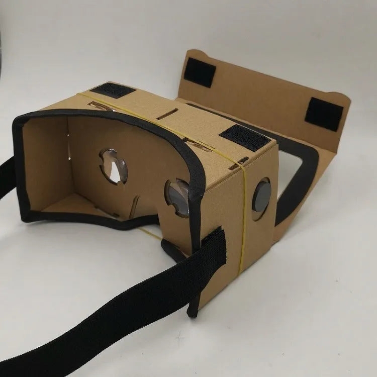 Foldable pink and white VR cardboard glasses headset for smartphones with adjustable strap and 3D lenses.