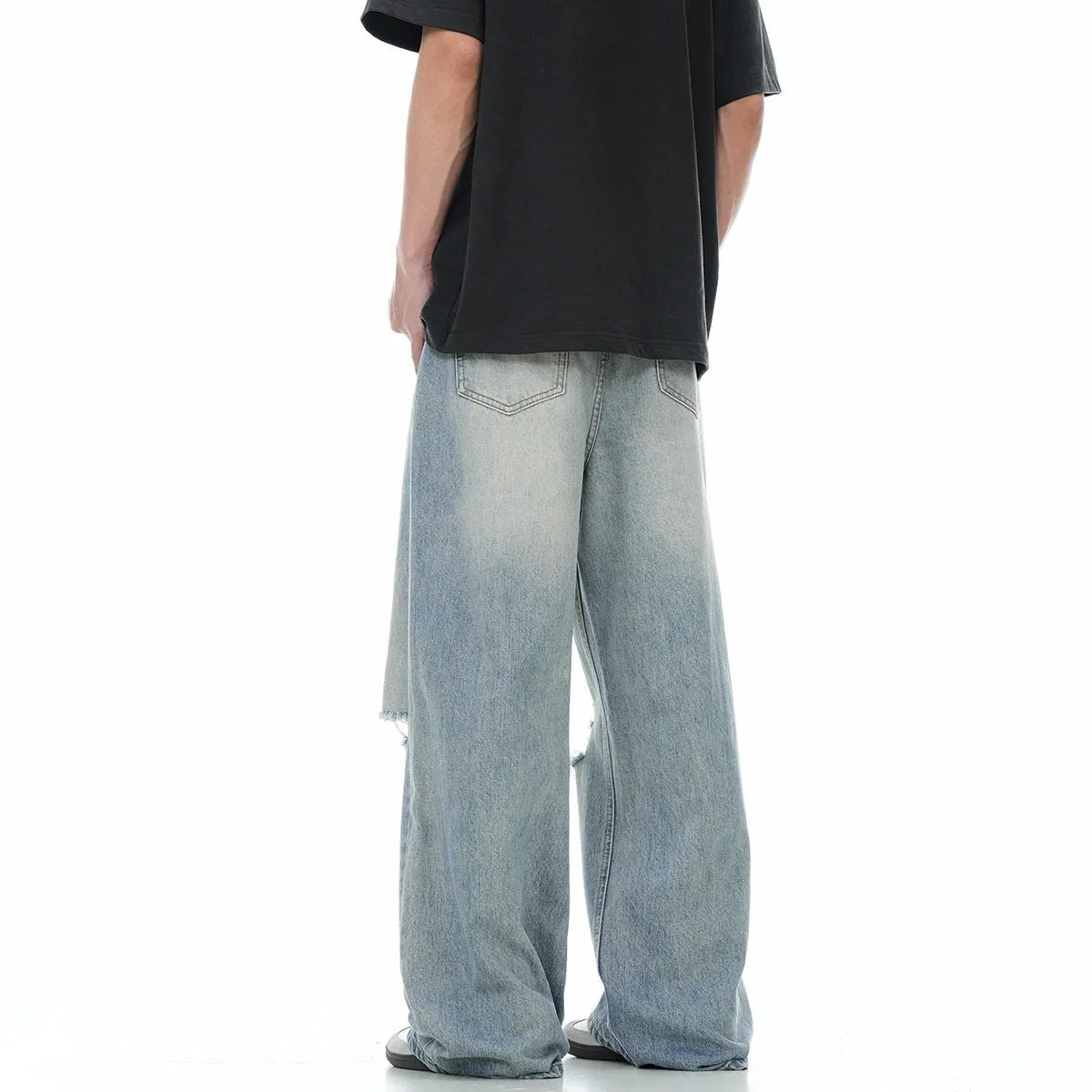 Blue men's straight-leg ripped jeans on a neutral background, showing zipper fly and cotton blend fabric texture.