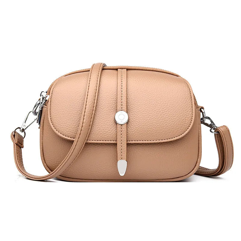 Women's oval crossbody shoulder bag in black, khaki or dark brown with visible sewing thread detail